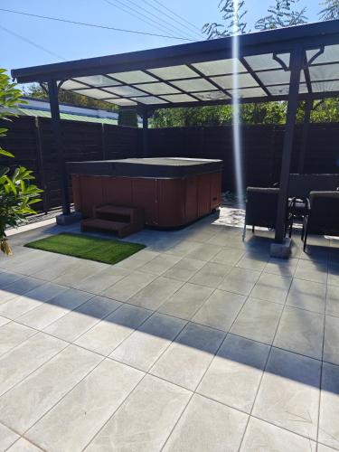 a patio with a hot tub under a pergola at Anna-Lak in Dunapataj