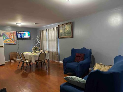 een woonkamer met een tafel en blauwe stoelen bij Glamour Room C 6mins to Newark Liberty International Airport and 3mins to Near Penn Station in Newark