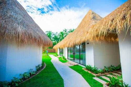 a resort with thatched roofs and a pathway at SEA SAND RESORT in Kampot
