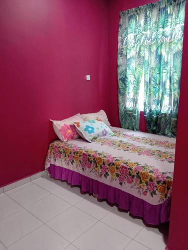 a small bed in a room with a pink wall at Pelangi Homestay 2 in Bachok