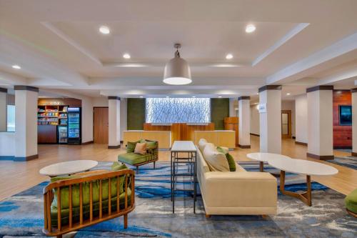 a lobby of a library with tables and chairs at Fairfield Inn & Suites by Marriott Greenwood in Greenwood