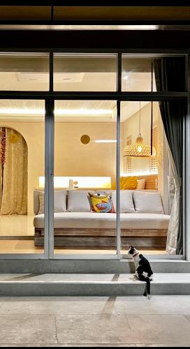 a black and white cat sitting in front of a room at Amity Beach Resort in Lamai