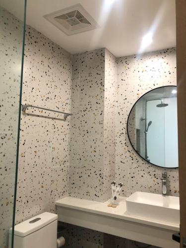 een badkamer met een spiegel, een wastafel en een toilet bij Fun Hotel in Panglao