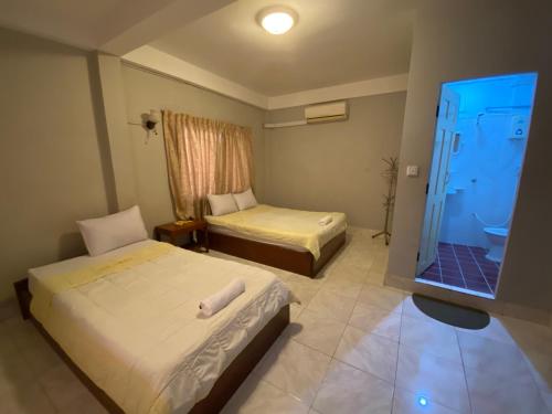 a hotel room with two beds and a television at The Grey Guesthouse in Phnom Penh