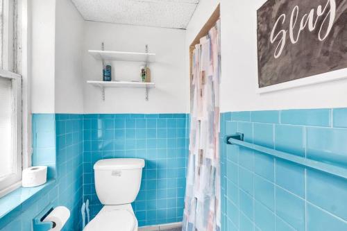 W wyłożonej niebieskimi kafelkami łazience znajduje się toaleta i prysznic. w obiekcie Private Remodeled Studio In Vibrant Center City w Filadelfii
