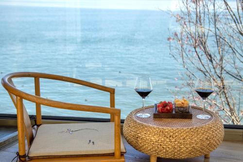 a table with a chair and two glasses of wine at Dali Beauty Seaview B&B in Dali