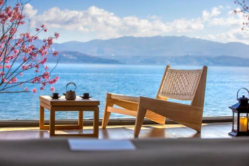 a patio with a table and a chair and a view of the water at Dali Beauty Seaview B&B in Dali