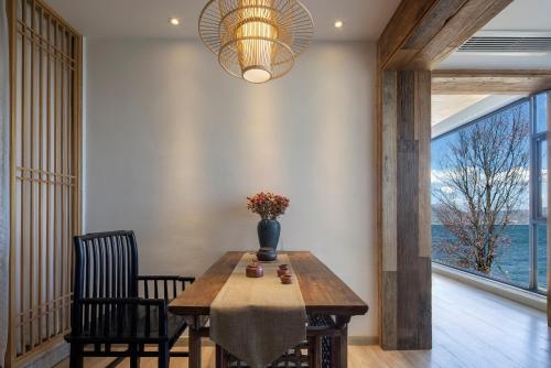 a dining room with a table and a vase with flowers on it at Dali Beauty Seaview B&B in Dali