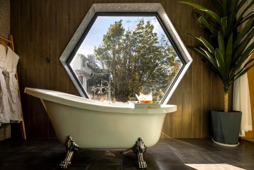 a bath tub in a room with a window at Dali Beauty Seaview B&B in Dali