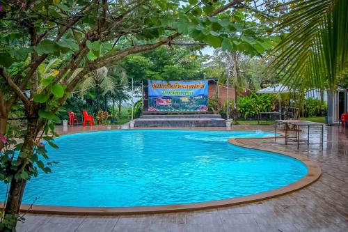 a large swimming pool with a sign in the middle at อุดมทรัพย์วิลเลจฟาร์ม in Ban Huai Nam Khem