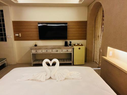 two white swans sitting on top of a bed at Amity Beach Resort in Lamai