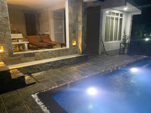 a swimming pool in front of a house at night at Amandara Hills Kandy in Kandy