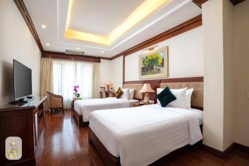 a hotel room with two beds and a television at Thien Thai Hotel & Spa in Hanoi