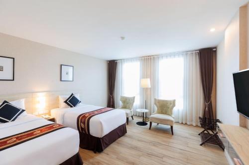 Ένα ή περισσότερα κρεβάτια σε δωμάτιο στο Le Cannes Hotel