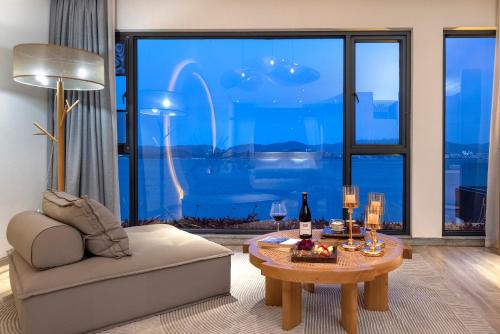 a living room with a couch and a table with wine glasses at Dali Beauty Seaview B&B in Dali