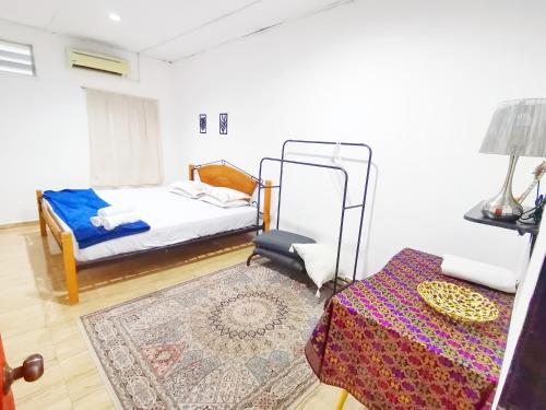 a bedroom with a bed and a table with a rug at Bluewave Sea Out Seaview Homestay in Kuah