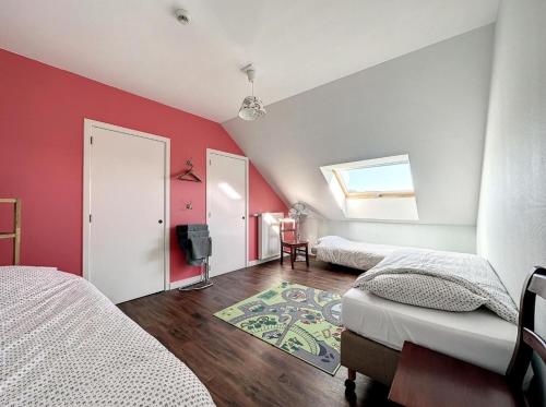 a bedroom with two beds and a red wall at La Cour de Grandmenil in Manhay