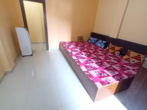 a bedroom with a bed and a refrigerator at Anand Yatri Grah - Home Stay, Ujjain in Ujjain