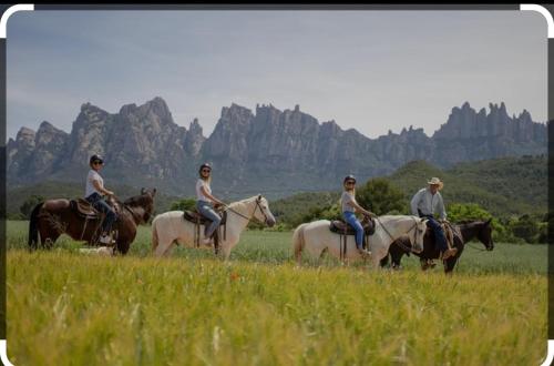 a group of people riding horses in a field at El Caliu in Barcelona