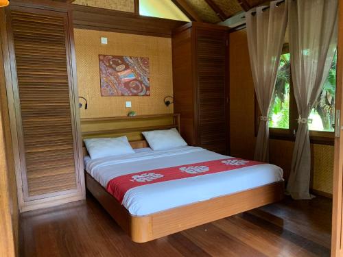 a bedroom with a bed with a red blanket at Le Nirvana - Oasis de Tendéa - Farino in Farino