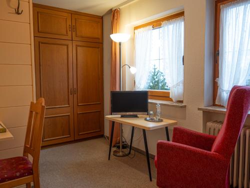 a room with a desk with a computer and a chair at Hotel Alpensonne in Riezlern