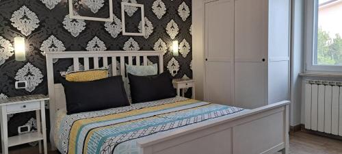 1 dormitorio con 1 cama con papel pintado en blanco y negro en Il Piccolo B&B, en Fiumicino