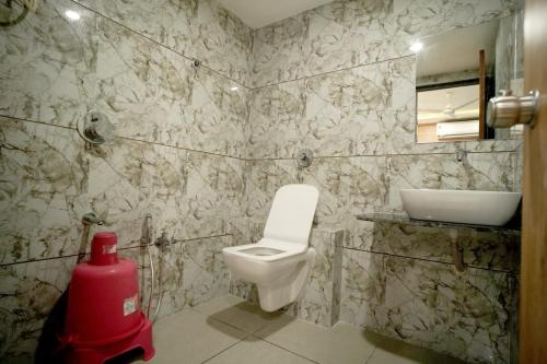 a bathroom with a toilet and a sink at Hotel Mahaveer in Ahmedabad