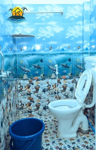 a bathroom with a toilet and a fish mural at V K HOLIDAY HOMEs in Malpe