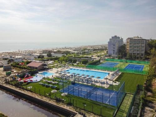 una vista dall'alto di una piscina con tavoli e sedie di Hotel Baya - in centro, sul mare a Milano Marittima