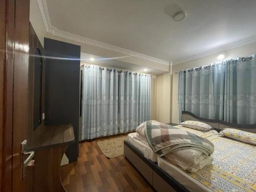 1 dormitorio con 1 cama, vestidor y cortinas en Basistha Home en Baudhatinchule