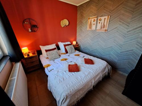 1 dormitorio con 1 cama blanca grande y paredes rojas en DE BLOEMENTUIN / A VIRÁGOSKERT en Tiszafüred