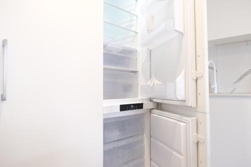 a white refrigerator with its door open at CBD Japanese Retreat 2BR 1P Brekky Wifi Netflix in Canberra