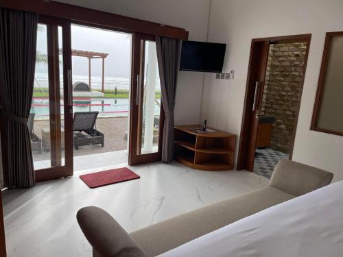 a bedroom with a bed and a view of the ocean at Rejuvenate Resort and Restaurant in Jembrana