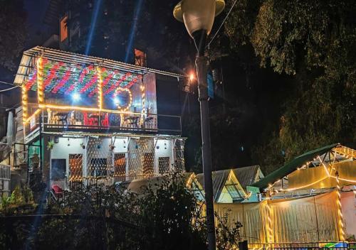 a building with a balcony with christmas lights on it at KASANA CLUB MUSSOORIE in Mussoorie