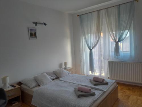 a bedroom with a large bed with two pillows on it at Apartman kod dide i bake in Vukovar