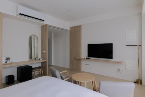 a room with a bed and a table and chairs at Terumahouse 照間 民宿編號2016號 in Taitung City