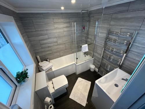 a bathroom with a shower and a toilet and a sink at Southpark House in Dumfries