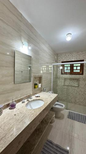 a bathroom with a sink and a toilet at Encanto Chalé in Monte Verde