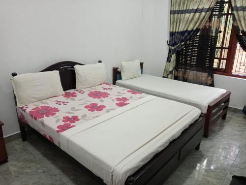 KalladyにあるSunny Fish Hotelのベッド2台が隣同士に設置された部屋です。