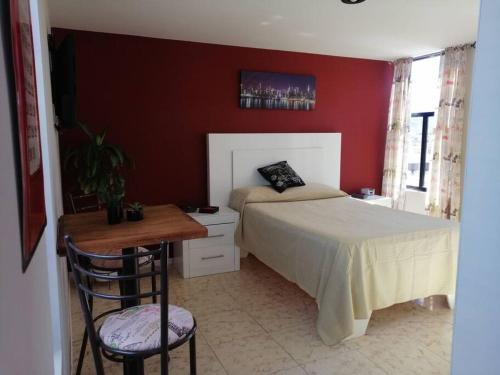 a bedroom with a bed and a table and a chair at New house in historic center, close to amenities. in Zacatecas