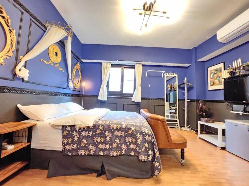 a bedroom with blue walls and a bed and a chair at 一中喵喵 有統編收據 禁菸 非自助 in Taichung