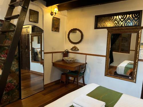 a bedroom with a bed and a table and a mirror at 103 - Bed and Brews in Bangkok