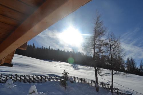 a person in the snow with the sun in the sky at Webertonihütte in Bad Sankt Leonhard im Lavanttal