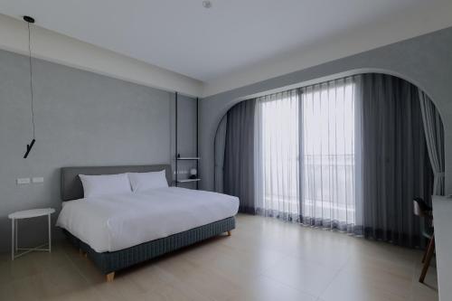 a bedroom with a bed and a large window at Terumahouse 照間 民宿編號2016號 in Taitung City