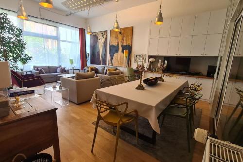 een woonkamer met een tafel met stoelen en een bank bij Le loft de Vincennes in Vincennes