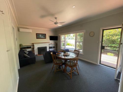 ein Wohnzimmer mit Tisch und Couch in der Unterkunft Cottage 32 in Lakes Entrance