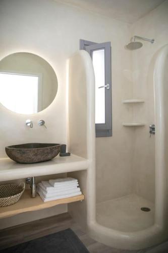 a bathroom with a sink and a shower with a mirror at White Nadora Naxos Villa in Agia Anna Naxos