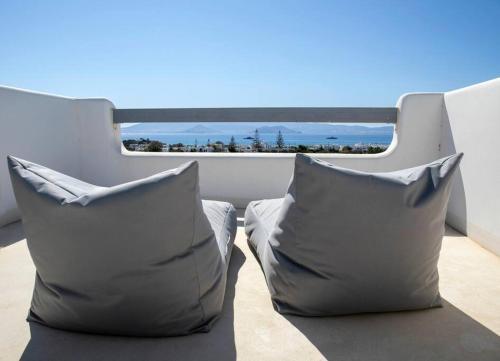 Duas almofadas numa varanda com vista para o oceano em White Nadora Naxos Villa em Agia Anna (Naxos)
