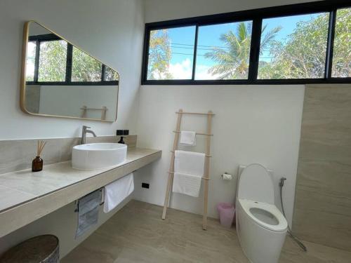 a bathroom with a sink and a toilet and a mirror at Роскошная вилла Lolux Villas in Srithanu