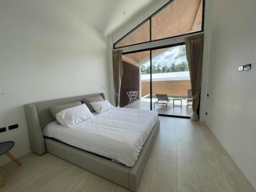 a bedroom with a large bed and a dining room at Роскошная вилла Lolux Villas in Srithanu